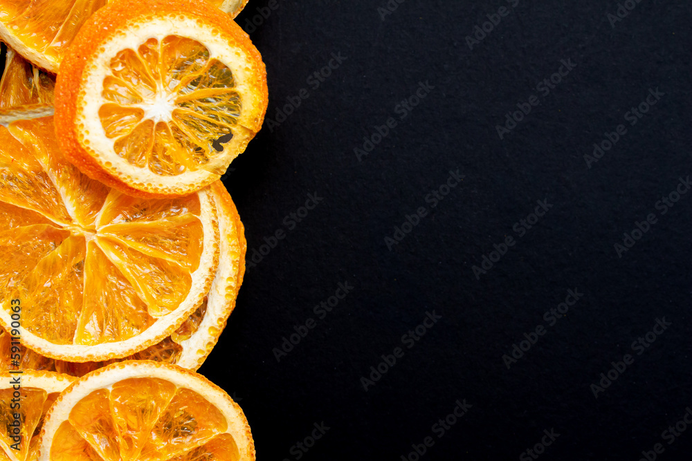 Poster dried orange slices on a black background with copy space for text. top view.
