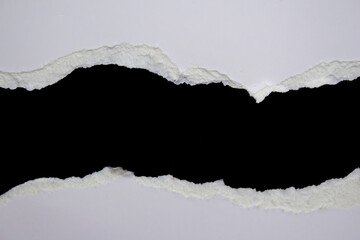 White ripped paper on a black background. Torn paper background with copy space.