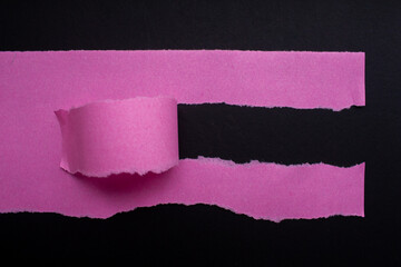 Pink torn paper texture background. Ripped paper on black background.
