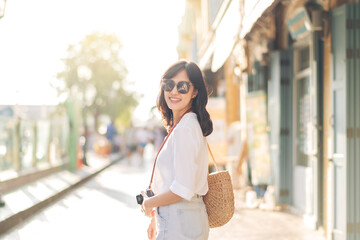 Portrait young beautiful asian woman with camera explore street on summer vacation in Bangkok, Thailand