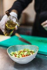 Close up shot of professional chef's hands working in restaurant kitchen. He prepares healthy delicious dish with fish and seafood.