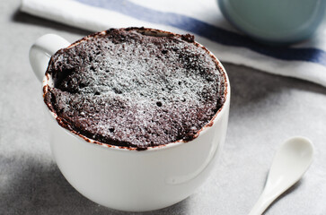 Chocolate Mug Cake, Homemade Cake Cooked in the Microwave on Bright Background