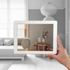 Augmented reality concept. Hand holding tablet with AR application used to simulate furniture products in custom architecture design, total white background, japandi living room
