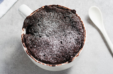Chocolate Mug Cake, Homemade Cake Cooked in the Microwave on Bright Background