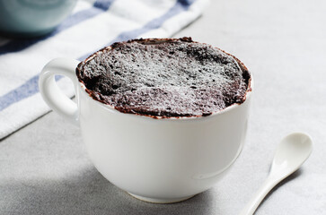 Chocolate Mug Cake, Homemade Cake Cooked in the Microwave on Bright Background