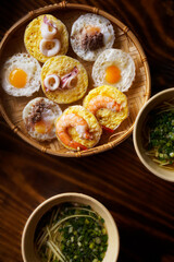 Banh Can stray, Vietnamese central street foods served with green onions dressing sauce on wooden table