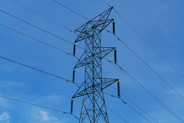 High voltage power lines against a blue sky