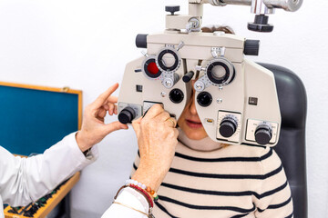 Optometry concept. Pretty young woman having her eyes examined by eye doctor.