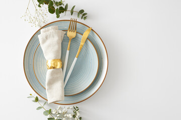 Table setting decor concept. Top view photo of circle plate cutlery knife fork fabric napkin with gold ring eucalyptus leaves and gypsophila flowers on white background with copyspace