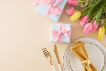 Mother's Day concept. Top view photo of gift boxes plate and napkin with ring cutlery knife fork colorful hearts and bunch of colorful tulips on pastel beige background with copy space