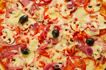 Freshly baked pizza with smoked sausages, red pepper, mushrooms, onion and olives served on wooden background with tomatoes, sauce and herbs. Food delivery concept. Restaurant menu