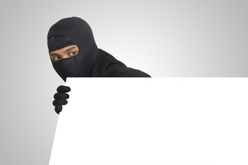 Mysterious thief wearing black hoodie hiding behind wall, sneaking, and looking for stolen goods....