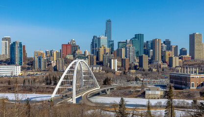 Skyline of Downtown Edmonton with the Walterdale Bridge in the view in the morning with blue sky during winter. © oasisamuel