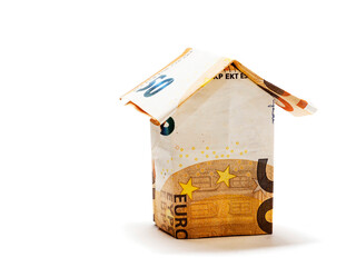 House made out of Euro bank notes on white background. Investing in property and real estate. New...