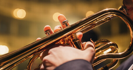 Cinematic Closeup of the Hands and Mouth of a Male Trumpet Player Reading a Music Sheet and Playing his Instrument. Professional Musician Rehearsing Before the Start of a Big Jazz Show - obrazy, fototapety, plakaty