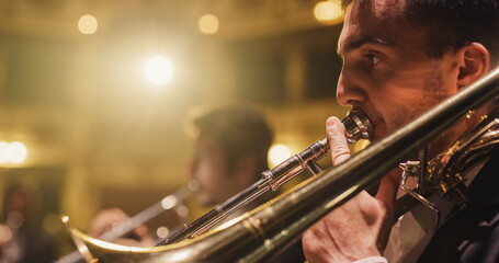 Cinematic Closeup of a Male Trumpet Player Reading a Music Sheet and Playing his Instrument....