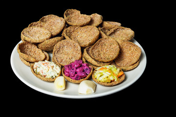 Rye bread toasts on a plate on a black background