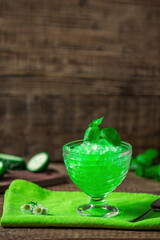 Summer Sicilian granite dessert, frozen juice of fresh cucumber and mint on a wooden background,...