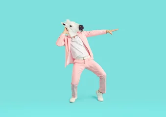 Deurstickers Carnaval Full length photo of funny man wearing bright pink suit in animal head horse mask dancing on studio blue background. Guy having fun. Entertainment, party, humor and advertisement concept.