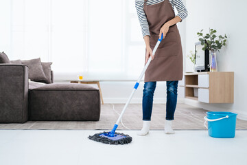 People, housework and housekeeping concept - Happy Asian woman or housewife with mop cleaning floor...