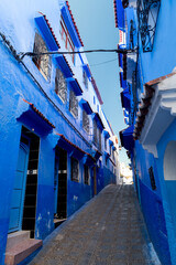 The typically narrow streets with the blue painted houses in the blue city of Morocco