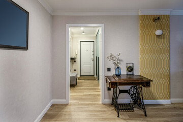 Fragment of a modern renovated room with a white doorway and an old table