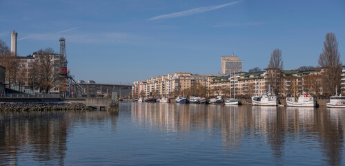 Waterfront apartment house and boats at a pier in the bay Hammarby sjö, a sunny spring day in Stockholm