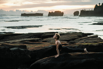 Young, beautiful girl - doing yoga and meditation on the beach.