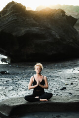 Young, beautiful girl - doing yoga and meditation on the beach.