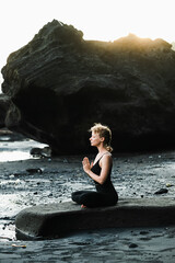 Young, beautiful girl - doing yoga and meditation on the beach.