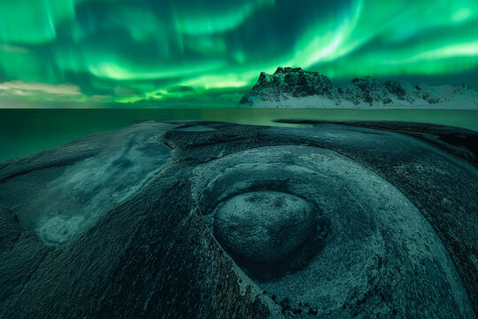 Aurora Borealis over the rock formation known as The Dragon's Eye, Uttakleiv beach, Lofoten and Vesteral Islands, Nordland, Northern Norway, Norway