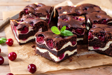 Obraz premium Brownie with cottage cheese and cherries on wooden table