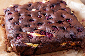 Brownie with cottage cheese and cherries on wooden table