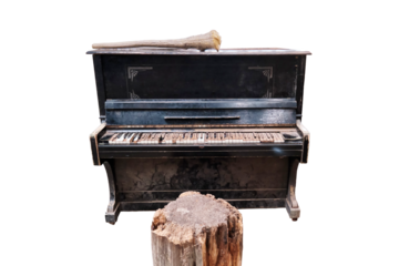 An old piano in a dirty room of an abandoned house, isolated on a white background. Black piano with white keys covered in dirt