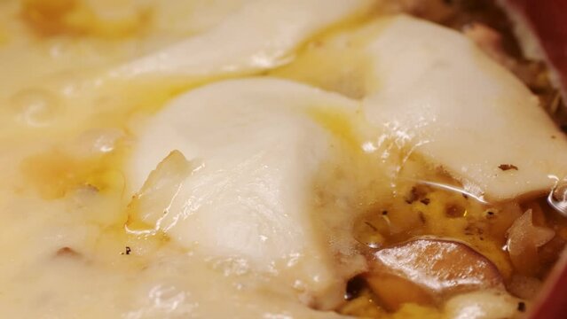 Melted cheese close up, melt pizza with cheese baking on tray in electric oven - macro, close up. Italian cuisine, homemade bakery, cooking food. 