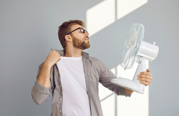 Too hot. Man suffers from summer heat. Young guy gets tired and exhausted of extremely high...