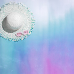 Summer flatlay with white sun hat and pink sunglasses at sunshine on colorful gradient background, neon colors. Creative aesthetic Life style summer sea holiday photo, abstract water texture