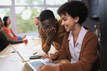 two professional businessmen discussing and using desktop computer in office