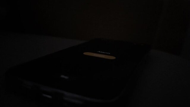 Good morning alarm clock on the tab on the desktop in the dark room , close-up