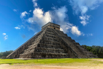 The pyramid of Chichen Itza in honor of the God Kukulkan the feathered serpent under a beautiful tropical blue sky, this castle of the Mayan civilization is one of the wonders of the world.