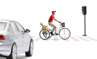 Guy riding a tricycle with a crate of fruits and vegetables at a pedestrian crossing