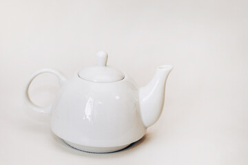 White ceramic teapot infuser on white background.