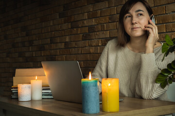 Young woman using laptop to work at home during electricity outage. Remote work at home concept....