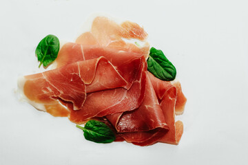 Pieces of dried pork jamon prosciutto on a white background.