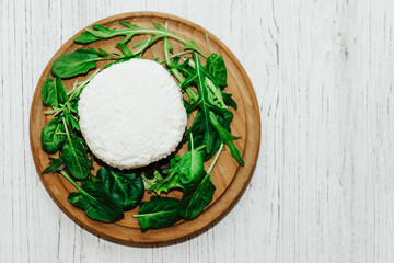suluguni pickled cheese on a wooden board with herbs.