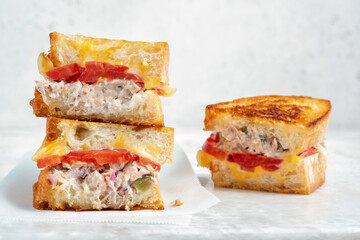 A closeup view of a tuna melt sandwich with cheese and tomato