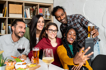 Friends with smartphone taking selfie, people having fun together, vegan food party