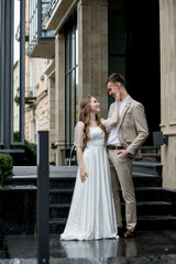 Obraz premium The bride looks at the groom with loving eyes. Smiling newlyweds look into each other's eyes.