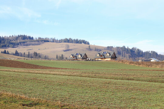 KACWIN, POLAND - NOVEMBER 09, 2022: Agricultural fields and wooden country houses in the background.