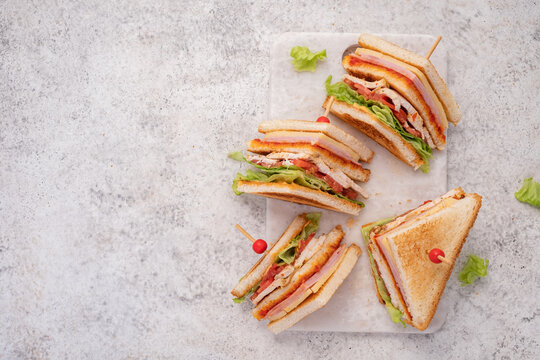 Club sandwich with ham, cheese, tomatoes, lettuce, and toasted bread